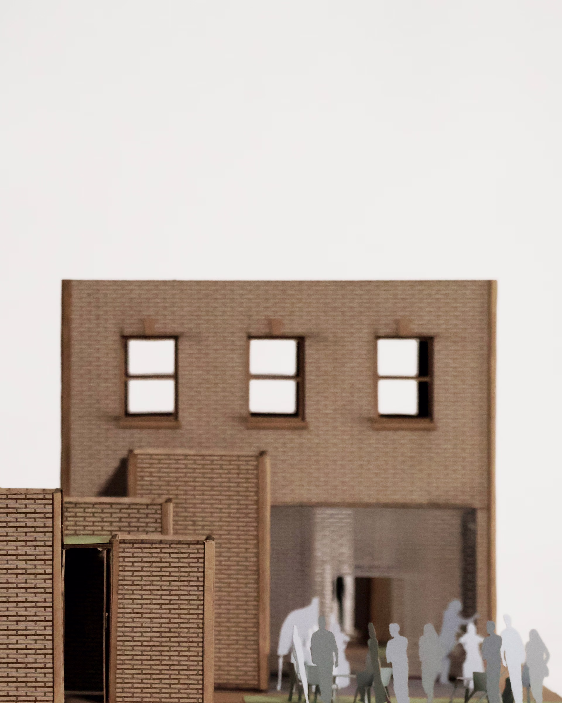 Rear facade detail of The Audio Alcove model, showing three upper windows above a glazed ground-floor opening.