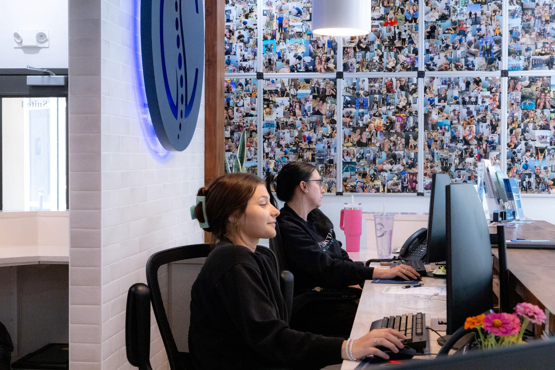 The Limitless Chiropractic front desk team offering a warm welcome to a new patient at our Mandeville office, ensuring a seamless check-in experience.