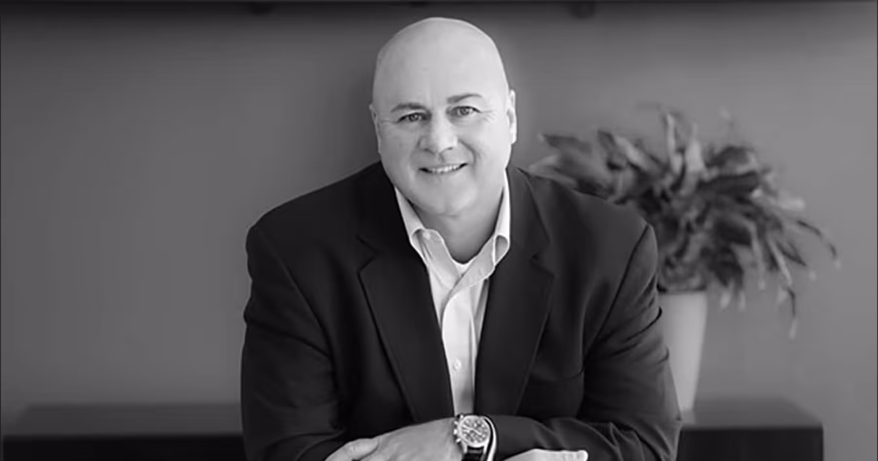 Black and white headshot of Lee Kestler in a suit against a grey background