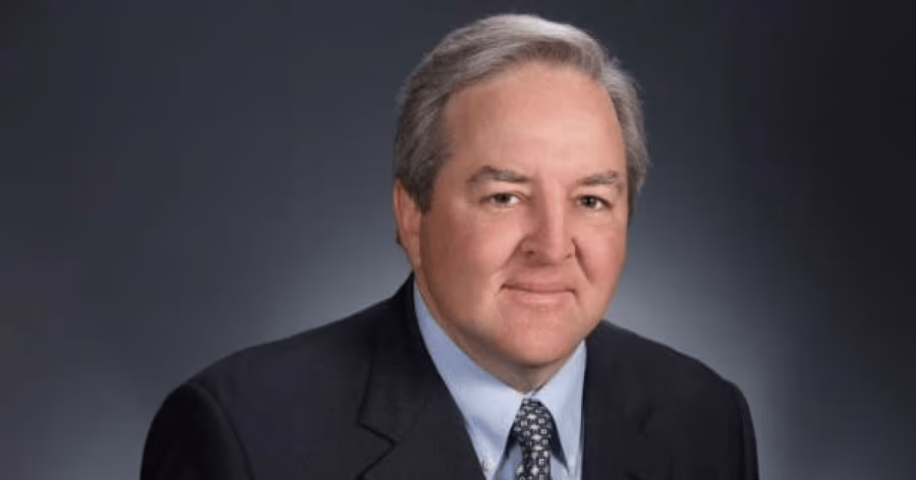 Headshot of Bob Berlinsky in a suit against a grey background