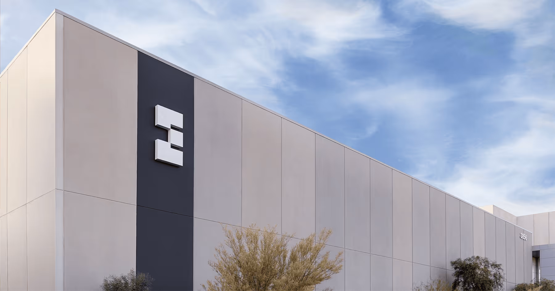 Exterior of a data center building with an EdgeCore monogram logo under a blue sky