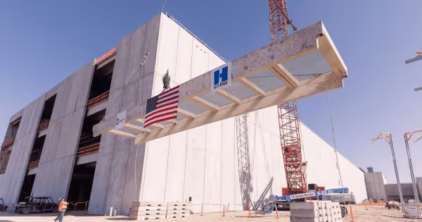 Exterior of a large data center building with glass facade under construction in a desert setting