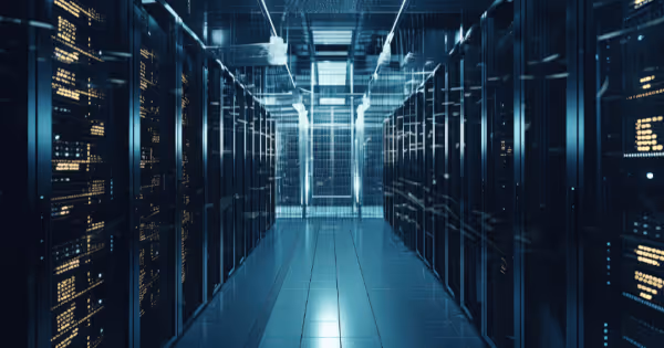Rows of glowing blue server racks stretching down a data center aisle