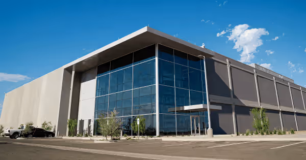 Exterior of a large modern data center building with glass windows under a blue sky