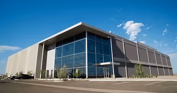 Exterior of a large modern data center building with glass windows under a blue sky