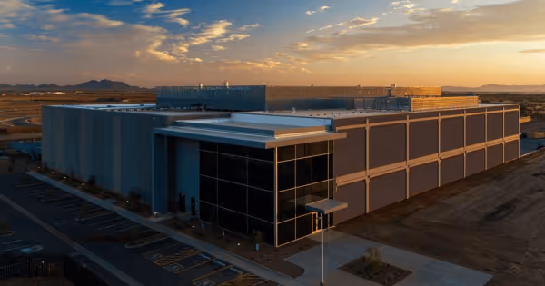 Aerial view of a data center campus at sunset with mountains in the background