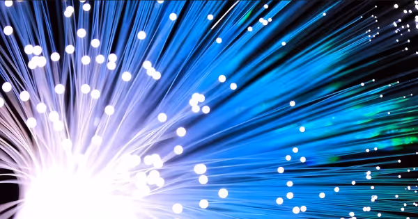 Burst of glowing blue and purple fiber optic light strands radiating outward