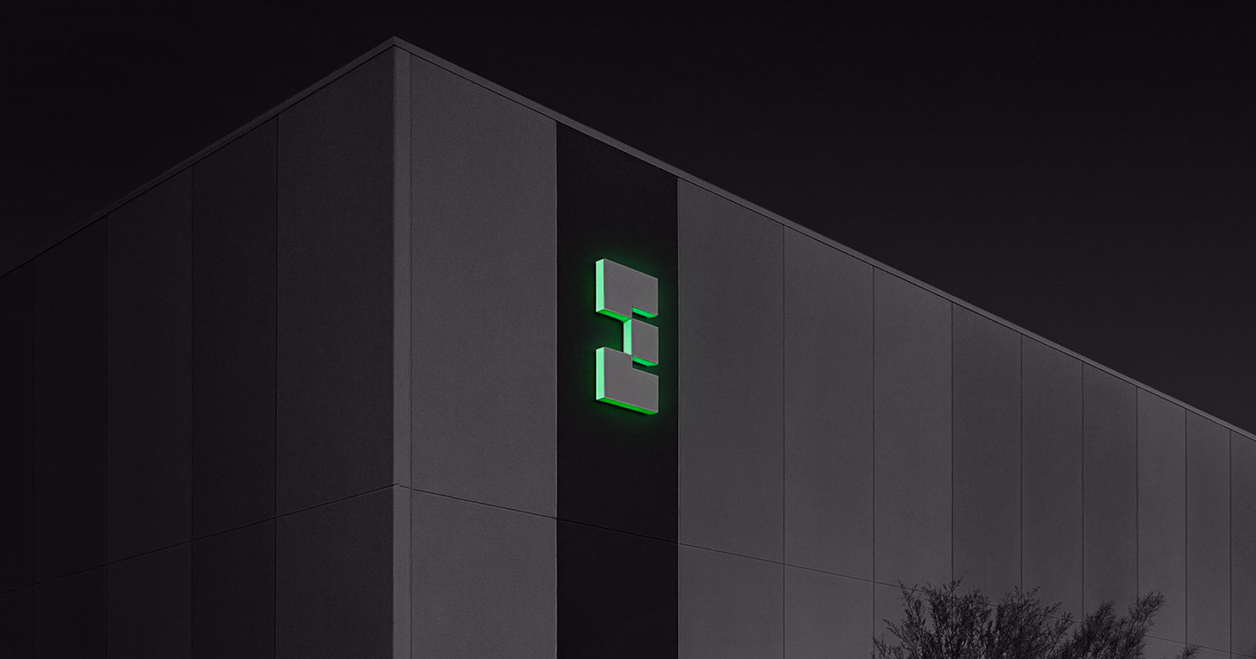 Data center building exterior at night with an illuminated green EdgeCore logo