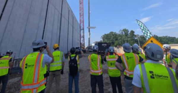 Construction crew and crane at a data center building site during a topping-out milestone