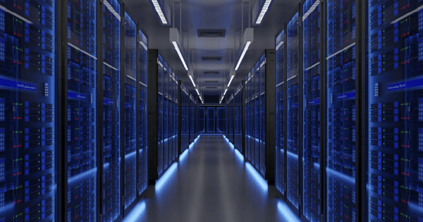 Row of server racks in a data center corridor lit in blue