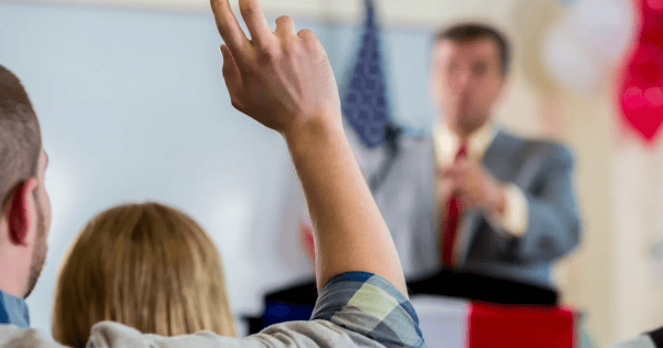 A person raising their hand during a presentation