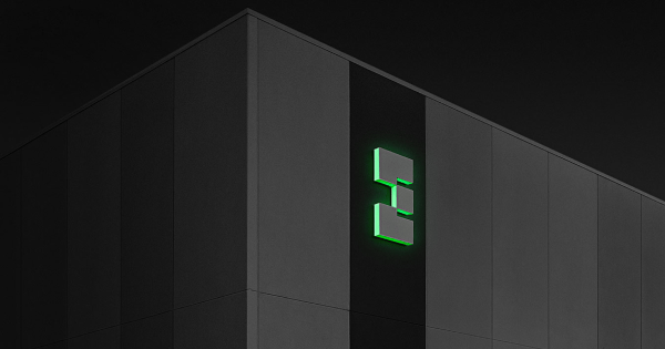 Illuminated green EdgeCore logo on a dark data center building exterior