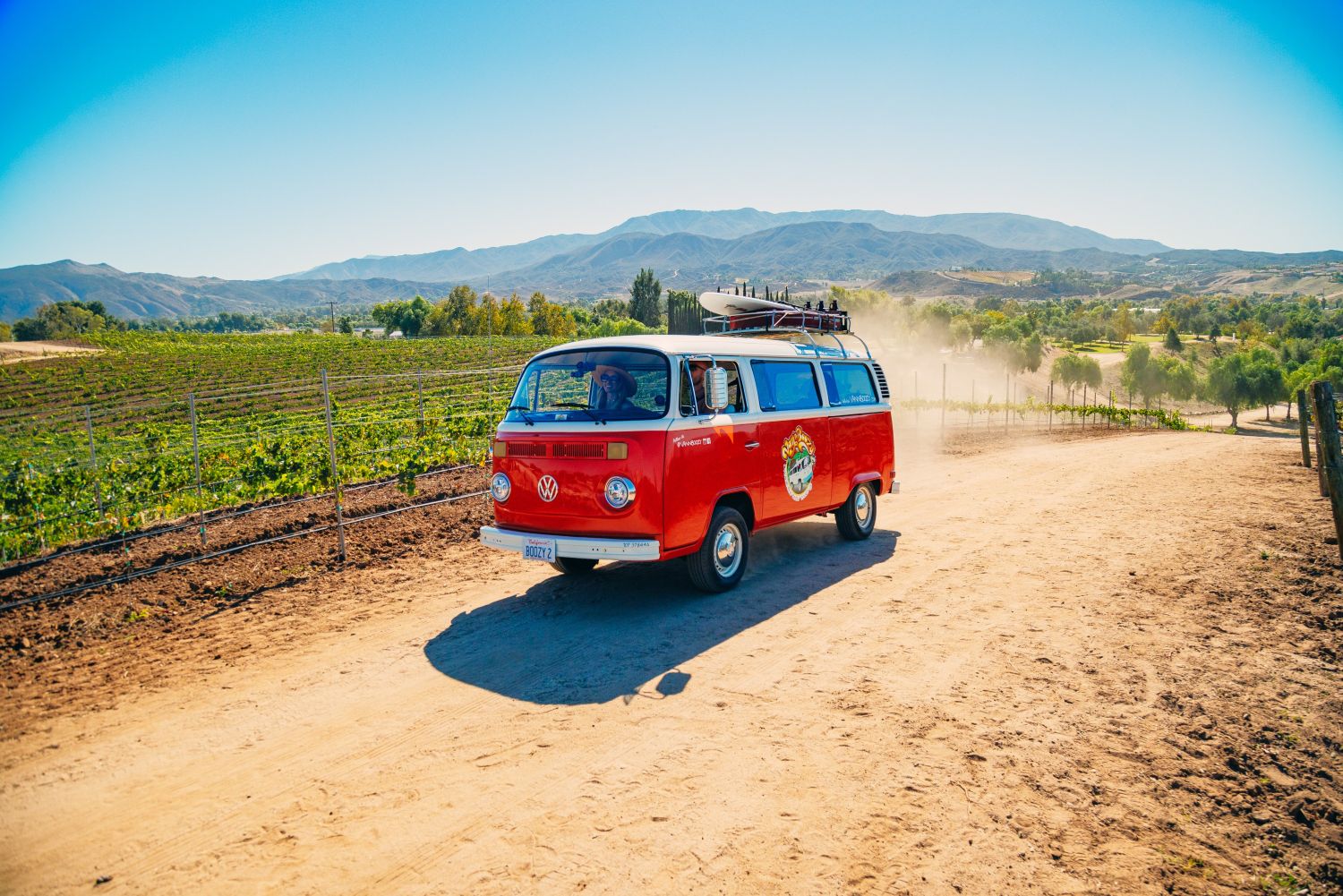Red vintage VW bus driving on a dirt trail through Temecula Wine Country during a Van'N Boozy Mocktail Tour.