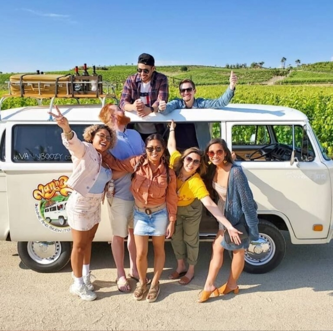 Happy group of friends posing outside a white VW bus on a non-alcoholic Temecula Mocktail Tour.