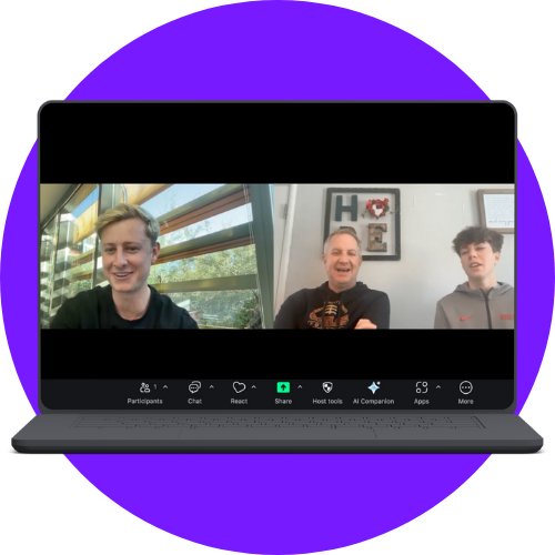 Laptop screen showing a video call with three men smiling, featuring a 'HOME' wall decoration in the background.