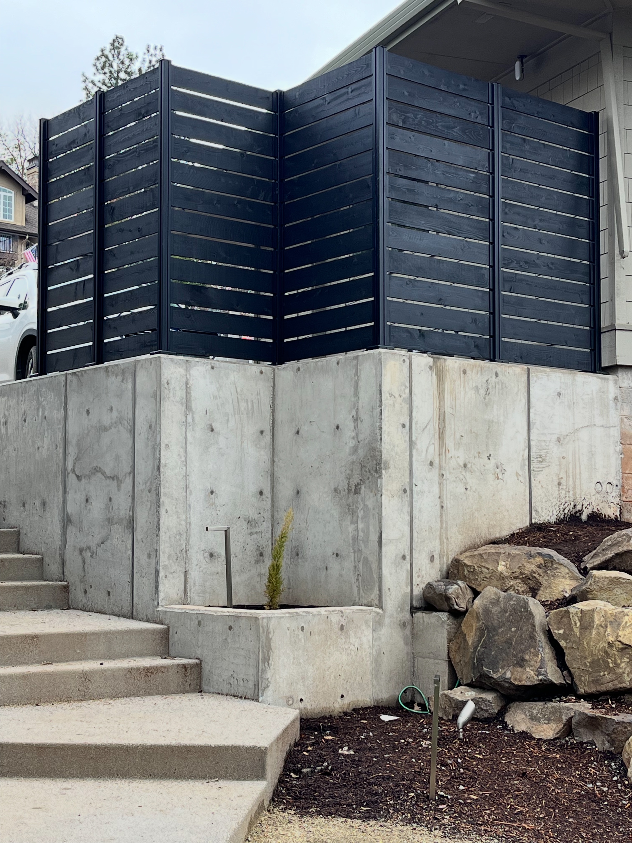 Modern concrete terrace with steps and a horizontal privacy fence