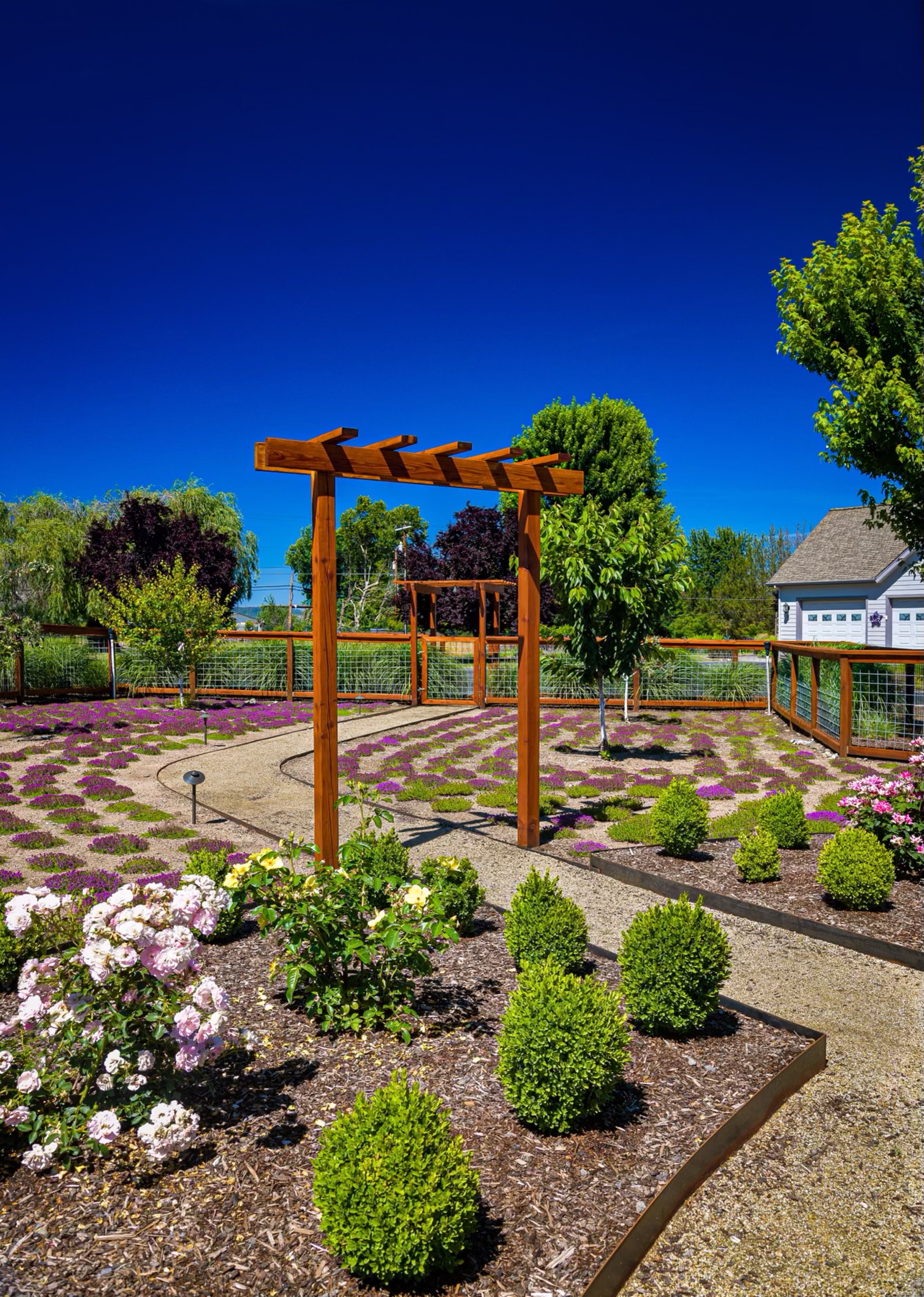 Formal garden enclosed by wire panel fencing and trellis details