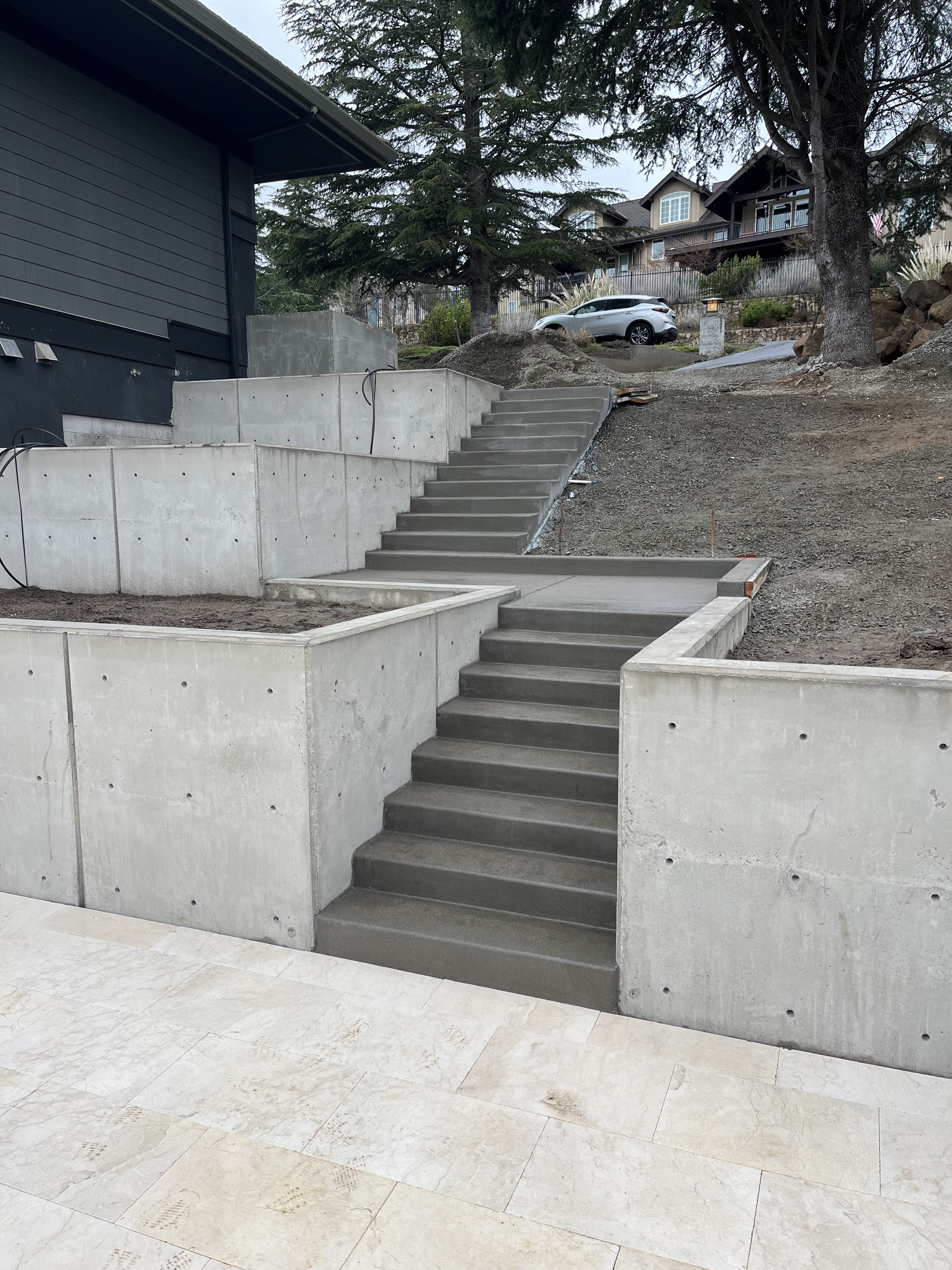 Finished elevated outdoor living area with patio and plantings