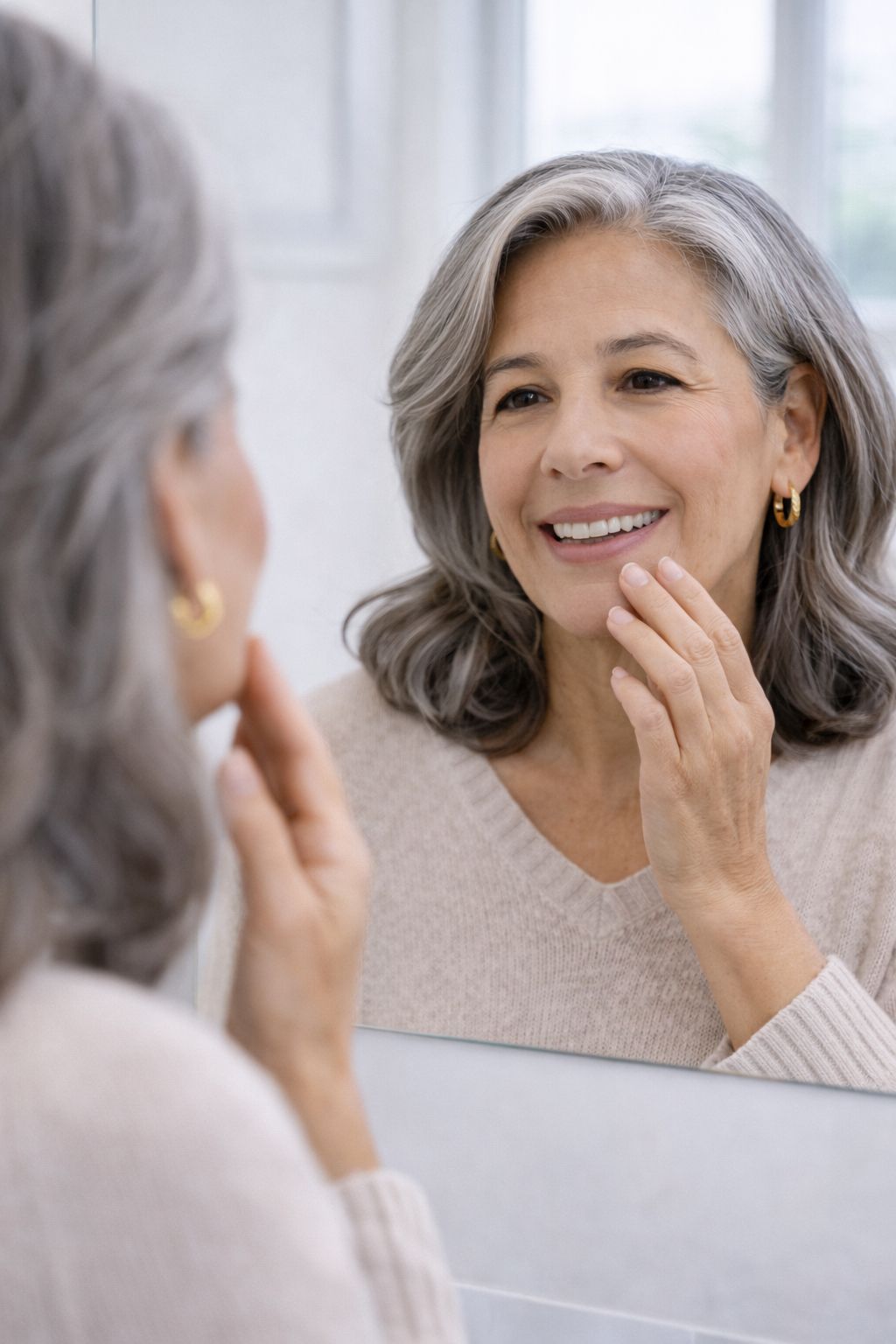 Paciente femenina adulta adaptándose a dentaduras frente al espejo en clínica dental en Tijuana | 