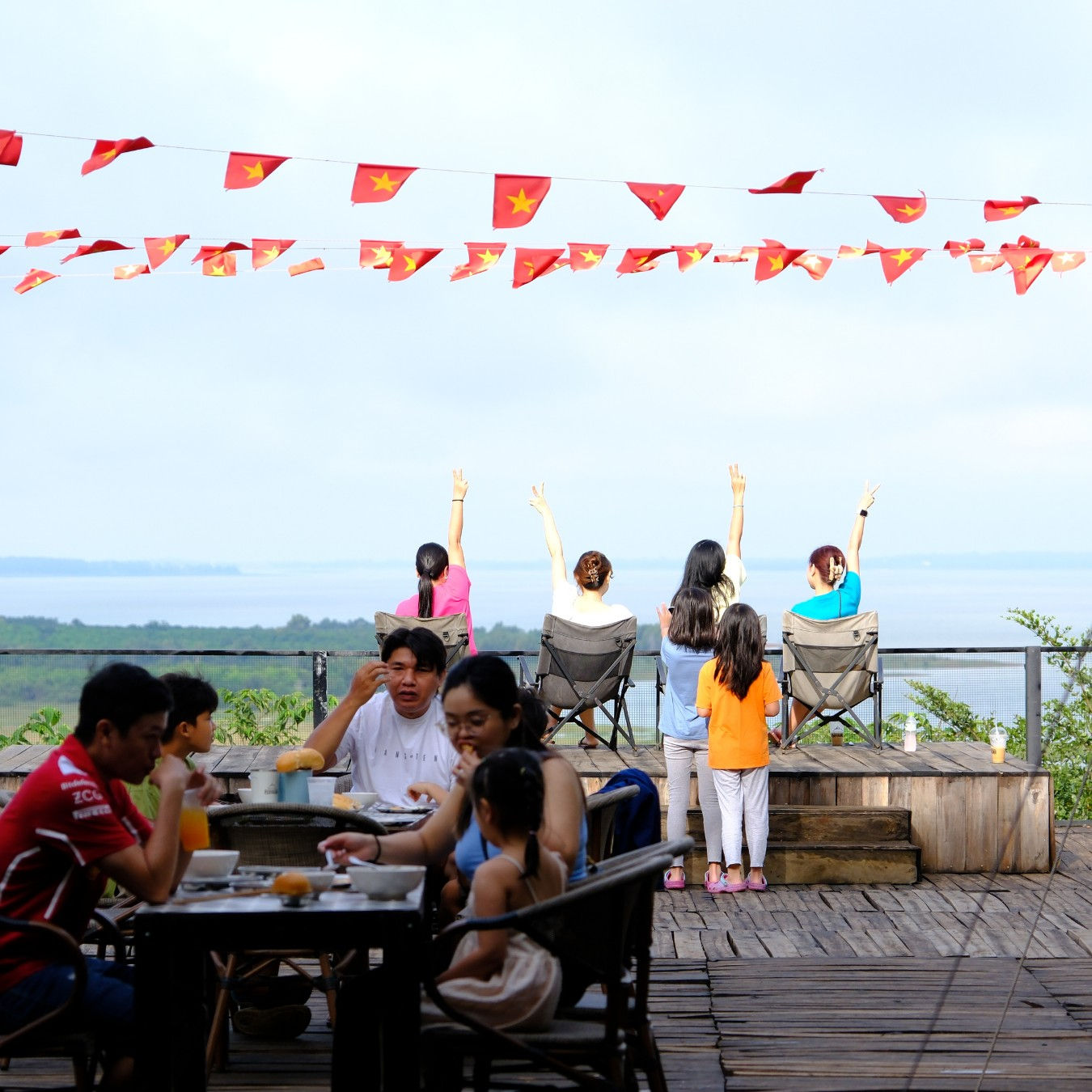 Khách glamping tận hưởng thời gian thư giãn ngoài trời, view hồ và cờ bay trong gió tại Panorama Glamping.