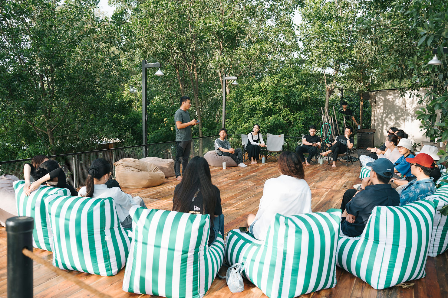 Wedding planner tham gia Famtrip tại Panorama Glamping Hồ Trị An, ngồi trên sàn gỗ dưới tán cây, trao đổi ý tưởng tổ chức lễ cưới và tiệc ngoài trời giữa thiên nhiên.