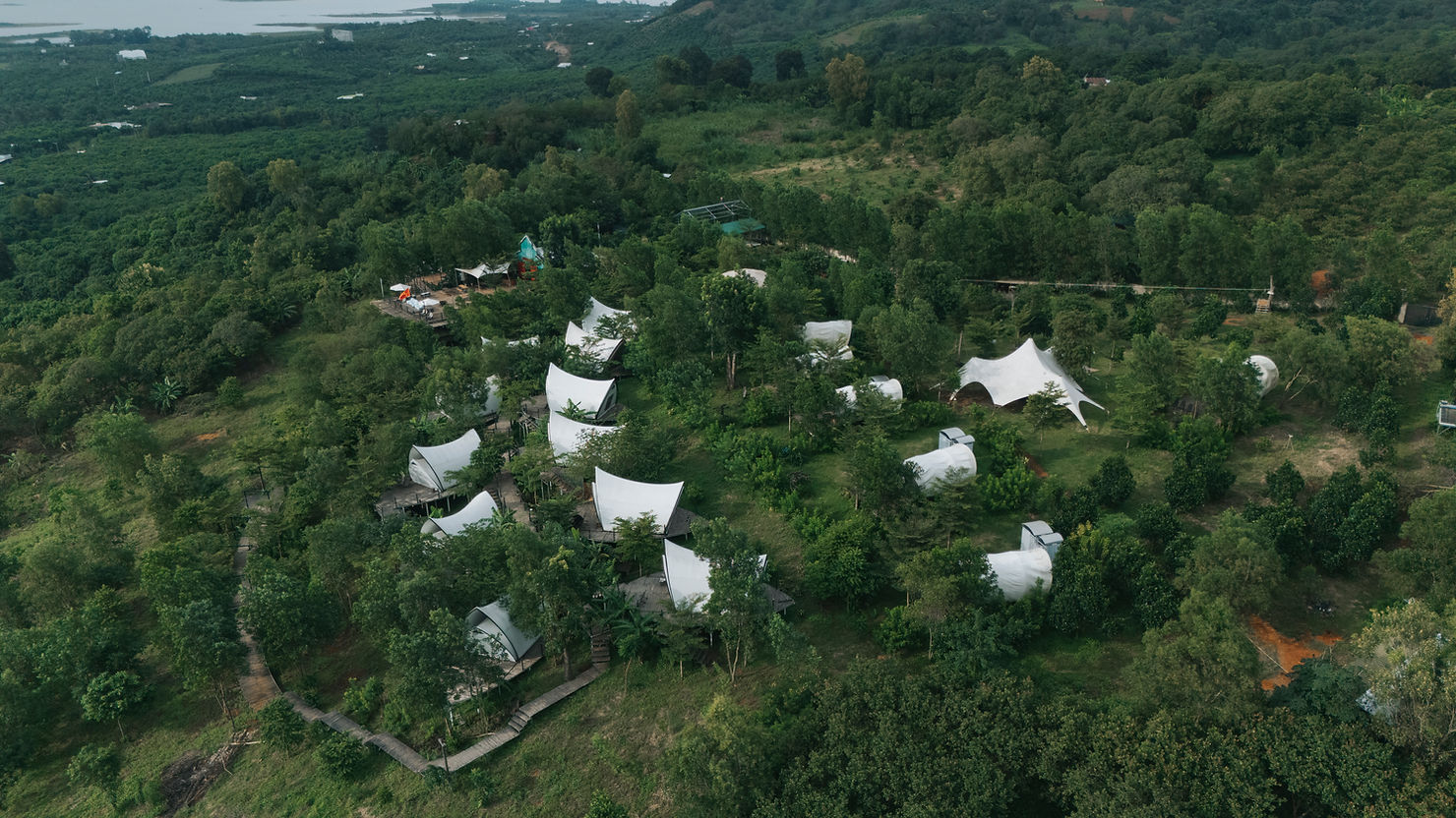 Toàn cảnh Panorama Glamping bên hồ Trị An – những mái lều Opera, Wagon và Dome ẩn mình giữa đồi xanh, ôm trọn tầm nhìn ra mặt hồ mênh mông. Giữa tuần, không gian tĩnh lặng và riêng tư như thuộc về chính bạn.
