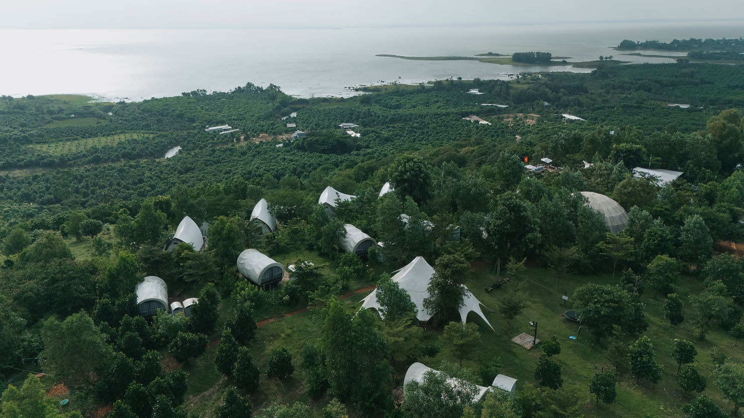Toàn cảnh Panorama Glamping Hồ Trị An nhìn từ trên cao – khu glamping giữa thiên nhiên với hệ thống lều Opera, Wagon và Dome tiện nghi, hòa mình giữa rừng xanh và mặt hồ khoáng đạt, điểm đến nghỉ dưỡng lý tưởng gần TP.HCM.