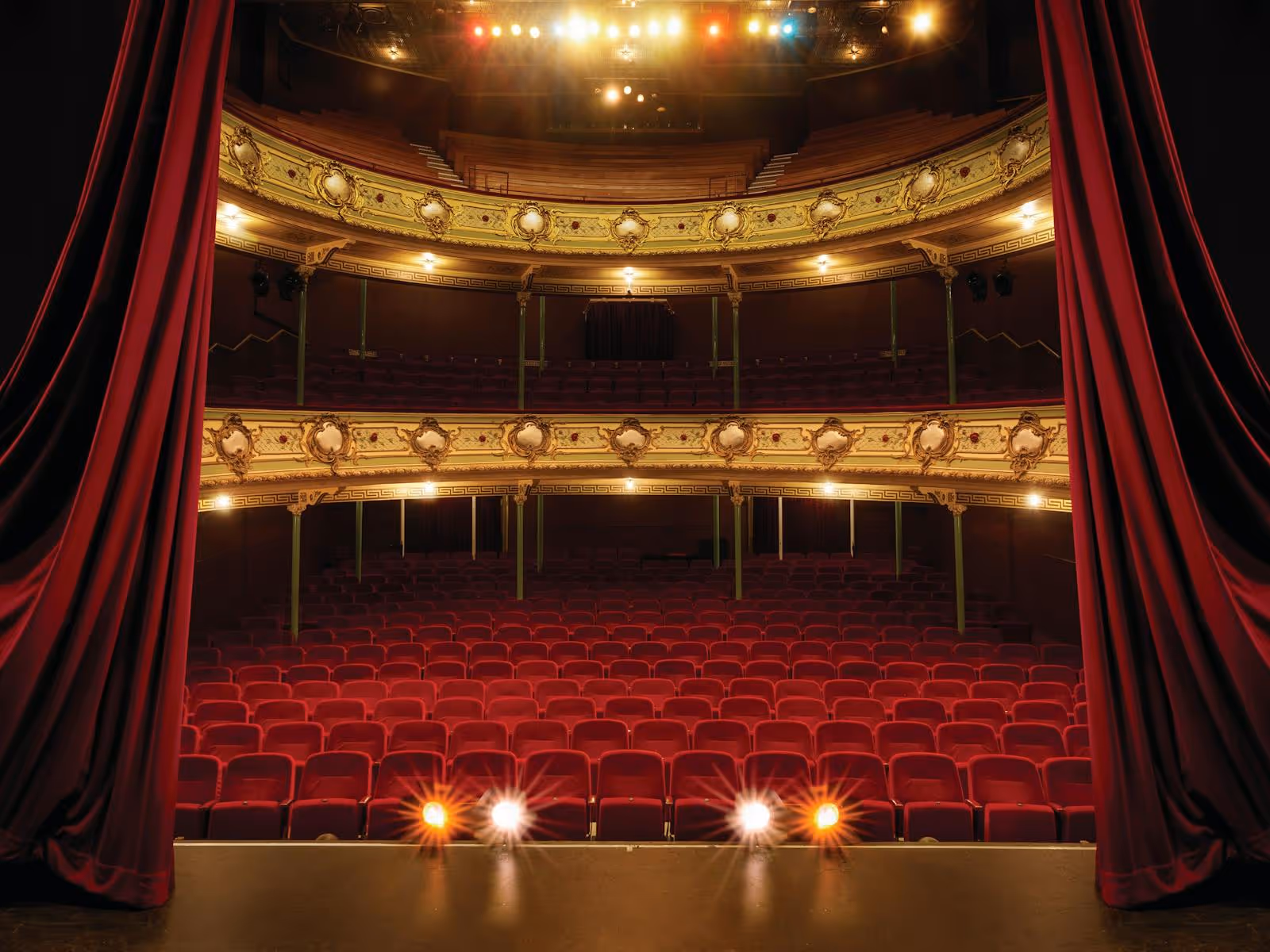 A theatre hall cloaked with red curtains.
