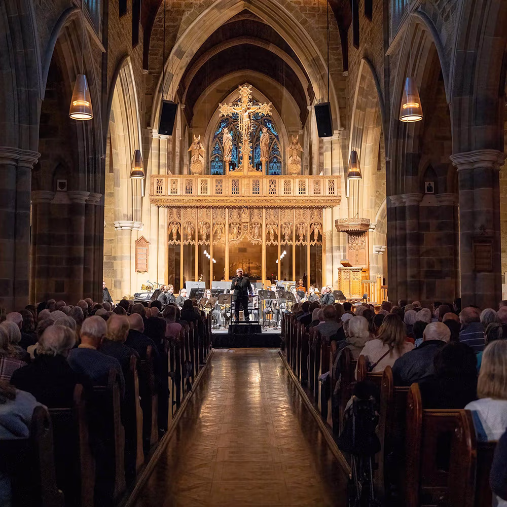 A cathedral filled with people watching a concert.