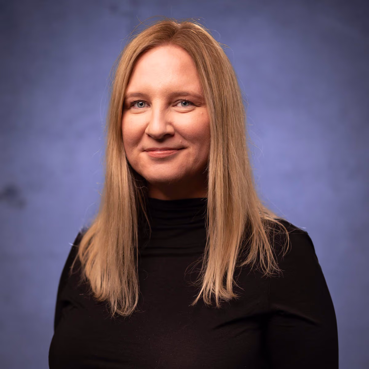 A blonde woman smiling at the camera.