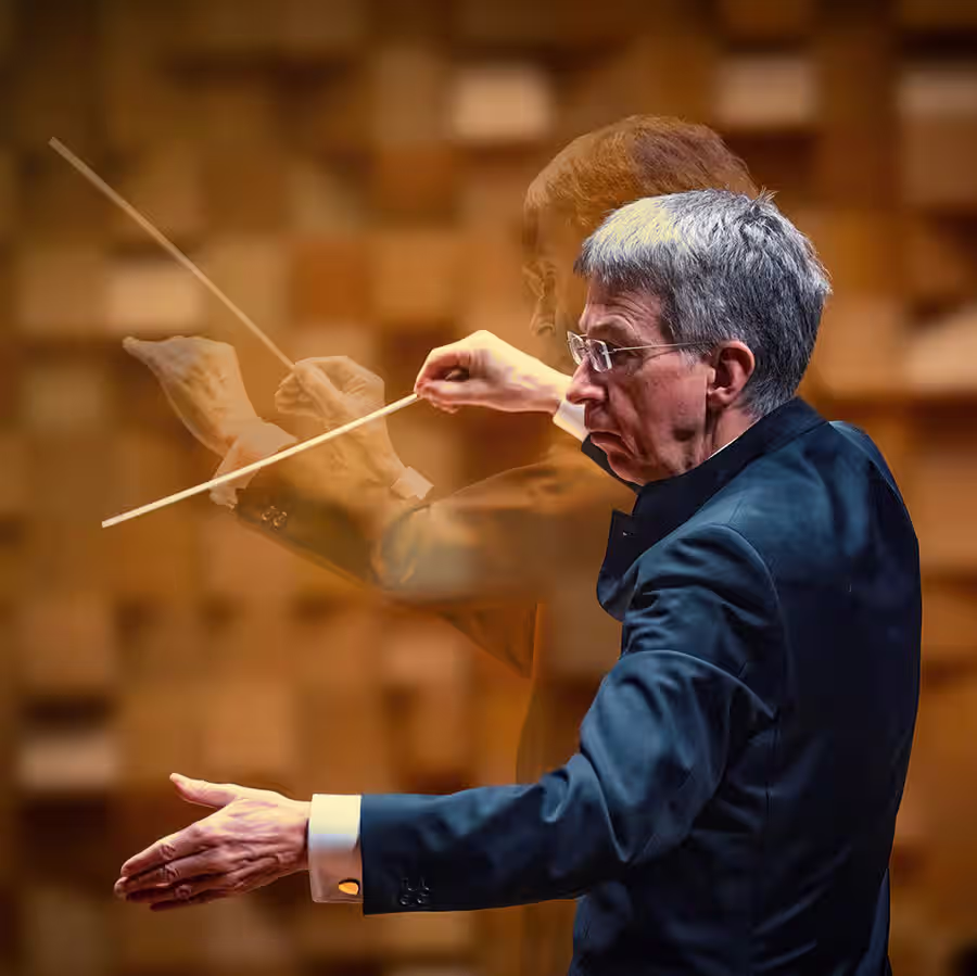 Eivind Aadland conducting, captured with a dynamic double exposure effect that shows his arms and baton in motion. The background features an abstract pattern of wooden blocks, enhancing the sense of energy and rhythm.