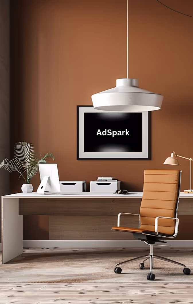 Smiling young man with short curly hair wearing a brown shirt against a dark background.