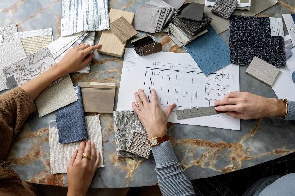 An image of Trevor Fulmer and Sophia Wensberg reviewing design project sketches and color swatches.