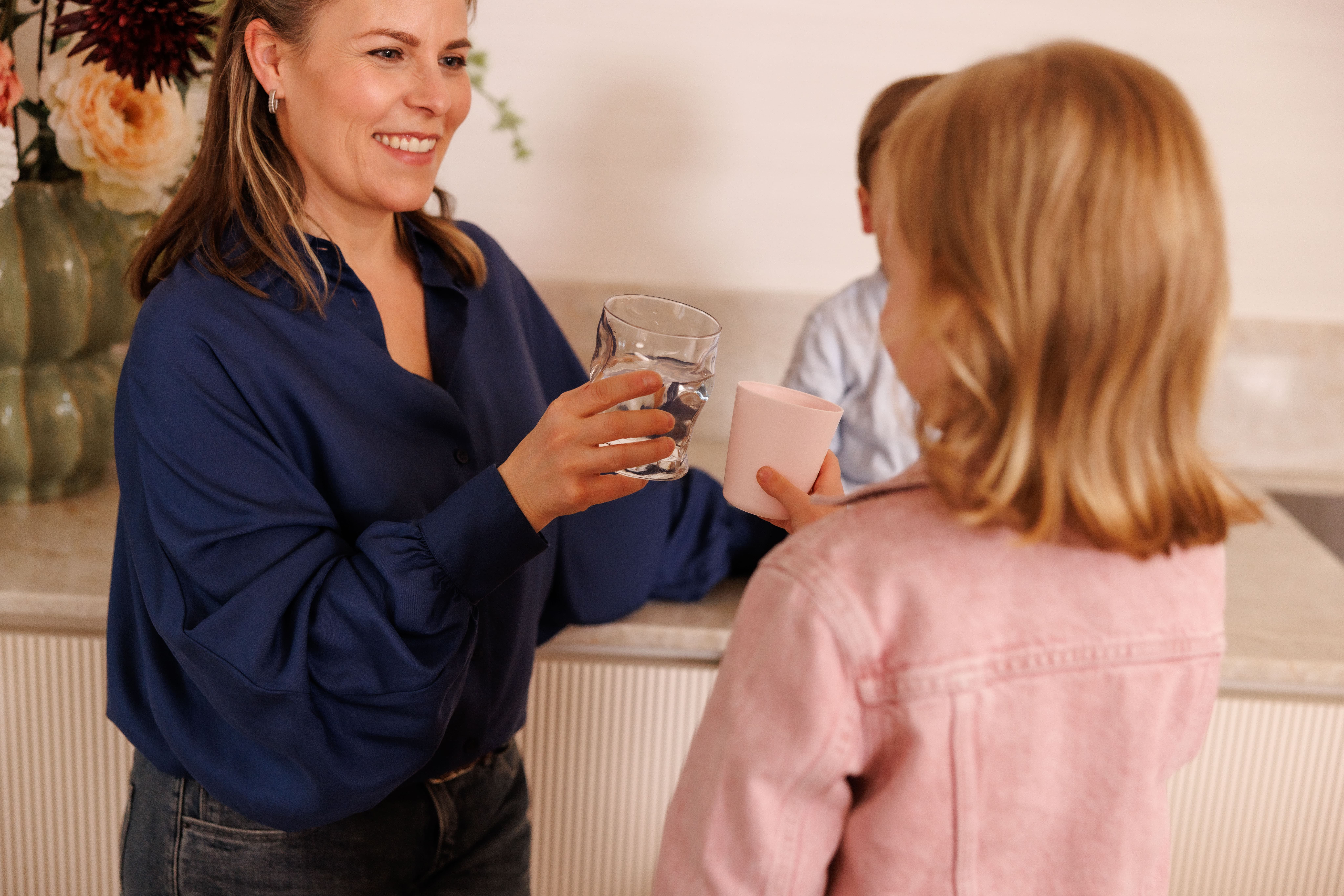 Danielle holding a glass of water for PeakSpring natural antioxidant hydration.