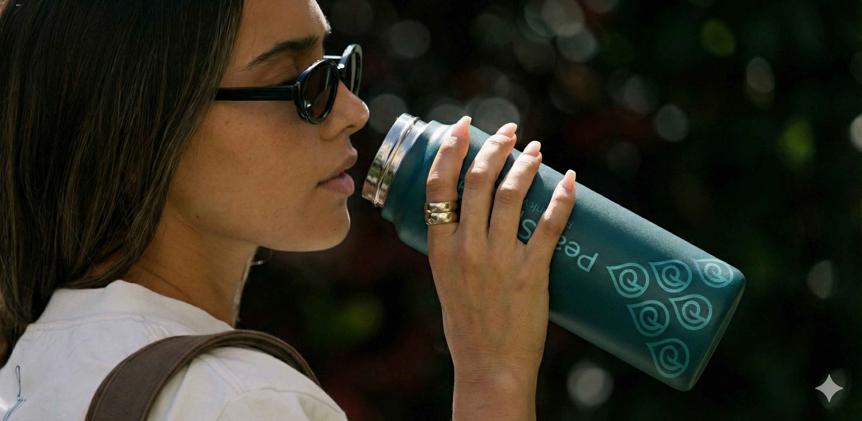 Woman drinking from a PeakSpring bottle representing an upgrade from tap water to better hydration.
