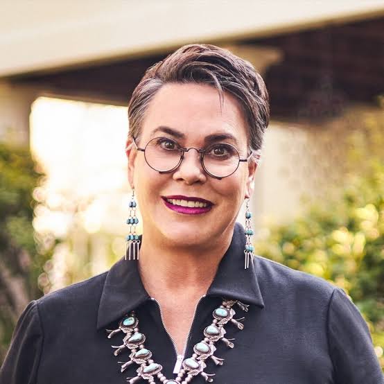 A woman wearing glasses and a necklace.