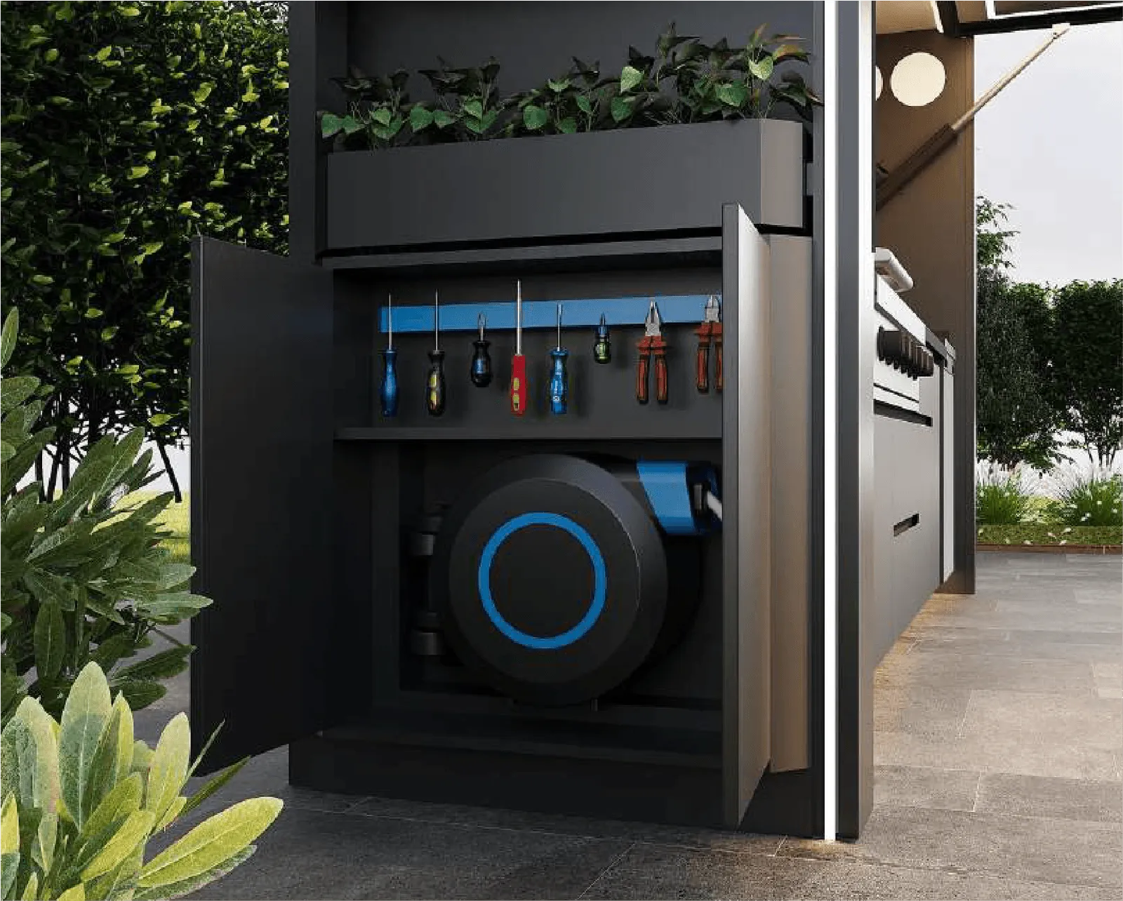Open black cabinet in an outdoor kitchen with tools hanging inside and a coiled hose reel mounted below.