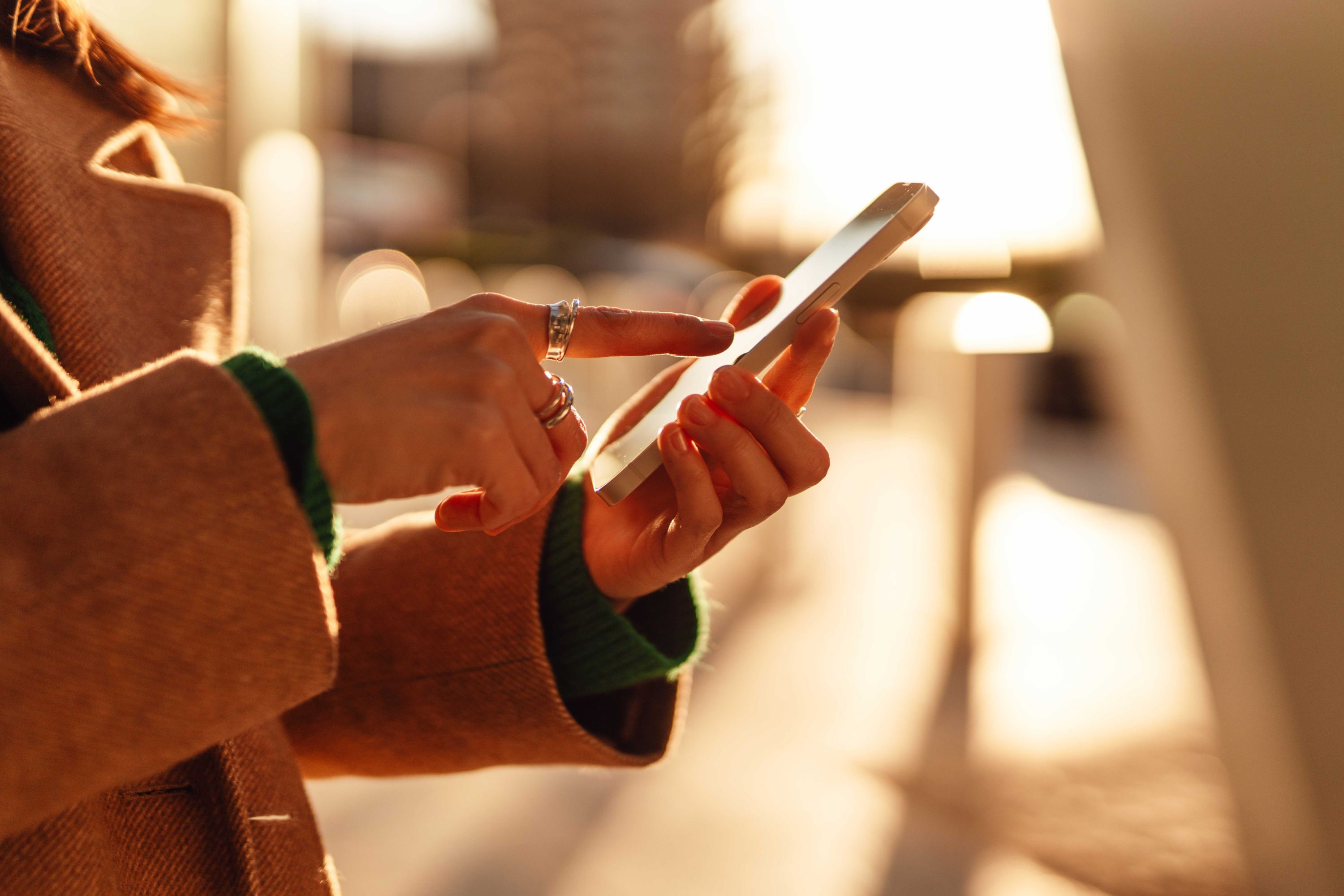 Woman using a smartphone in a city during a sunset