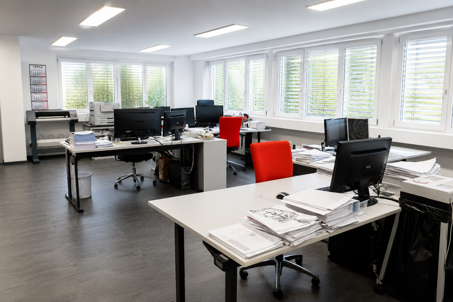 Drei rote TERRA-Mützen, jeweils mit Stift, USB-Stick und Notizblock auf einem Tisch arrangiert.