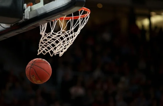 Basketball dropping through a hoop during a game