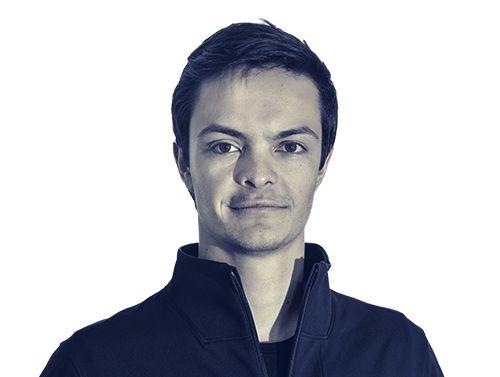 Portrait of a young man with short dark hair wearing a dark zip-up jacket.