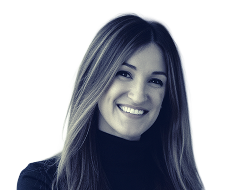 Smiling woman with long straight hair wearing a dark turtleneck against a light background.