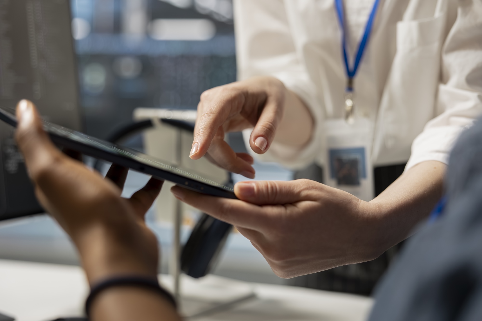 Engineers examining software logs and metrics on a tablet in a data center.
