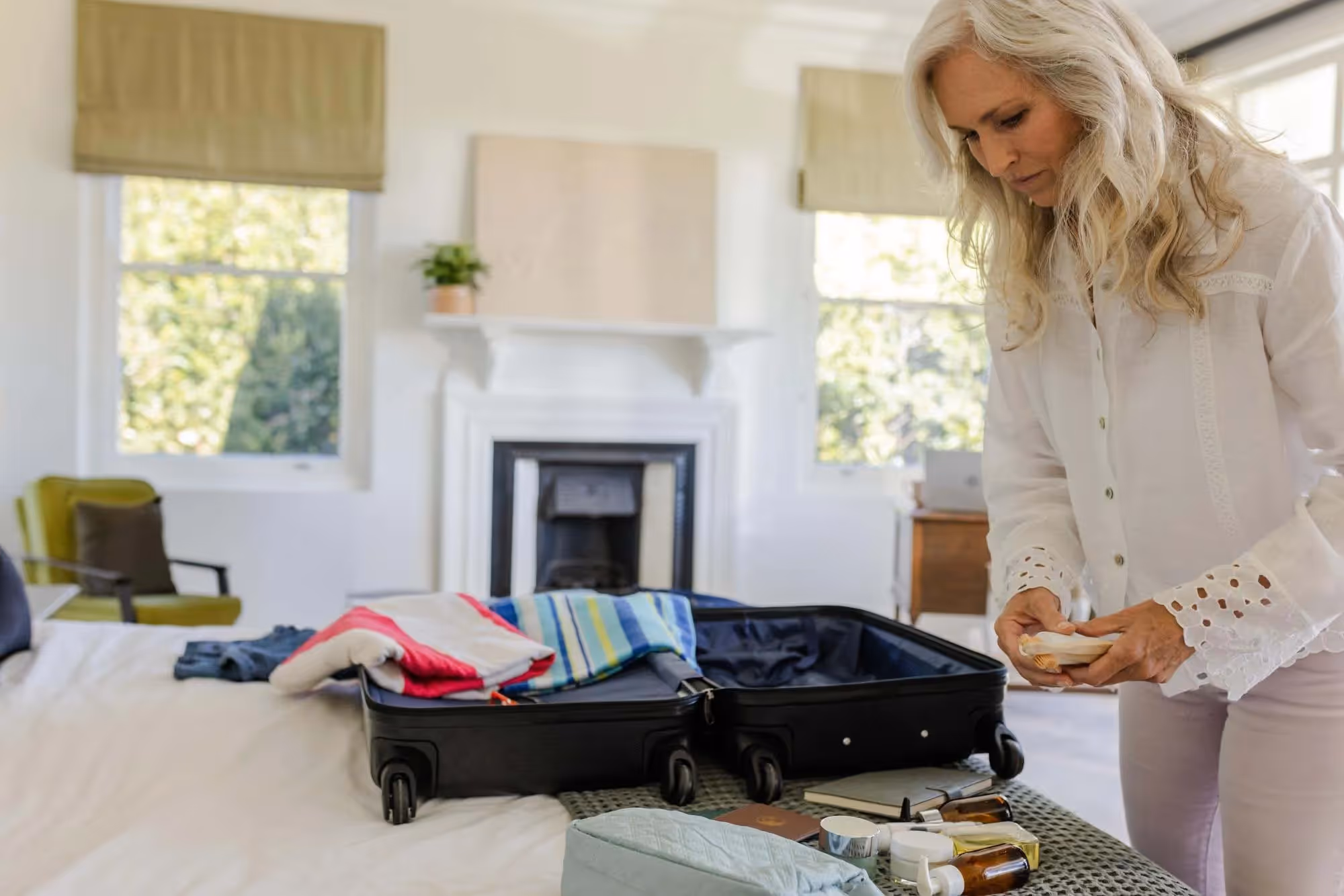 A woman packing items into a suitcase ready for a a holiday