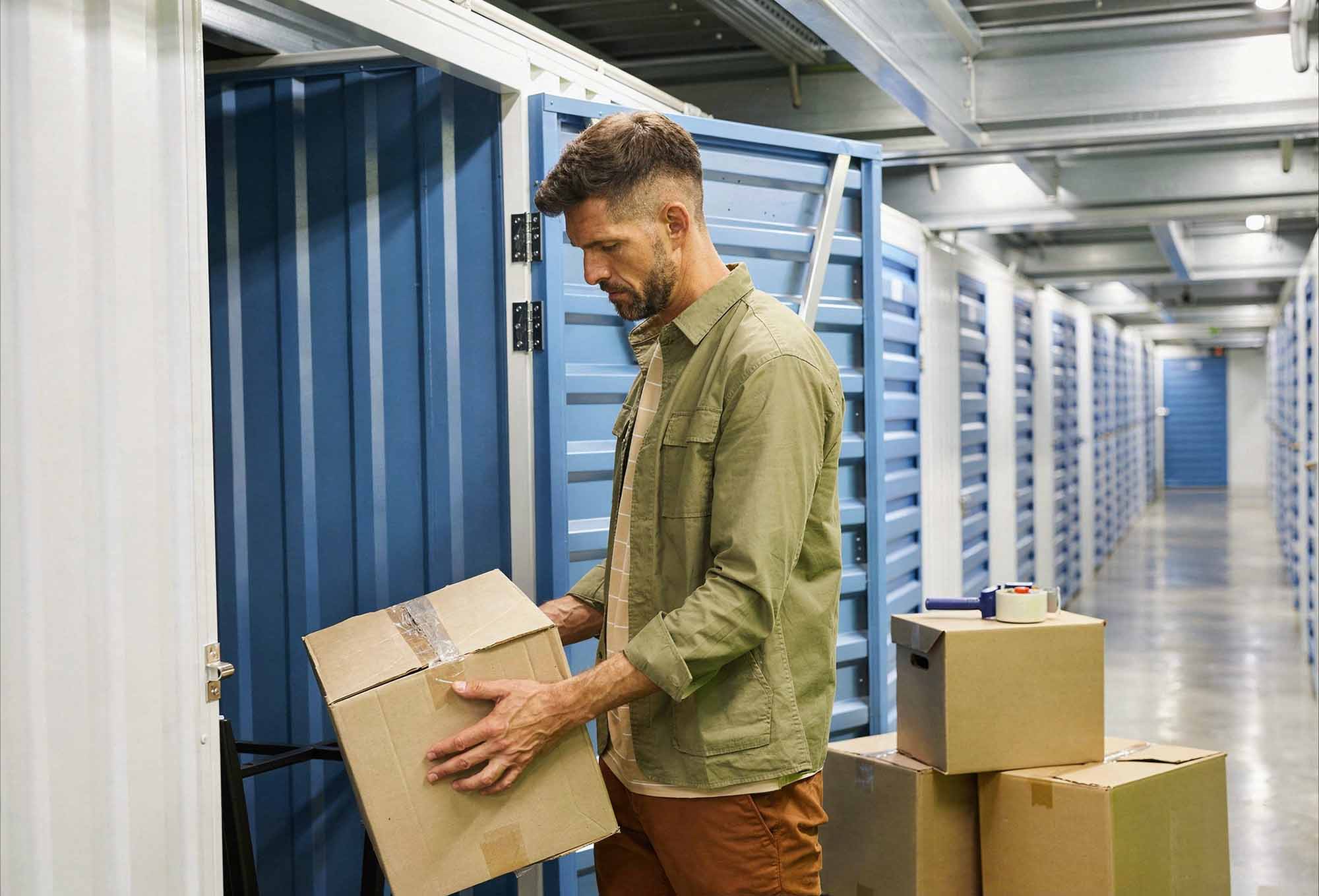 A man placing a box inside a self-storage unit