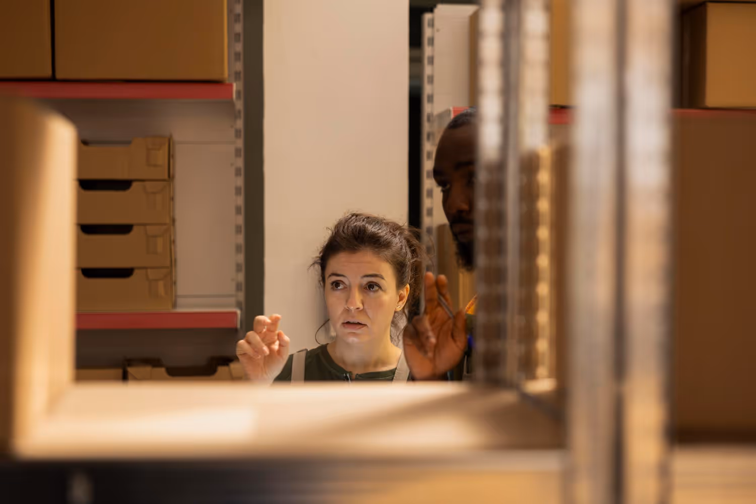 A man and a woman inspecting stock on shelves inside a storage unit