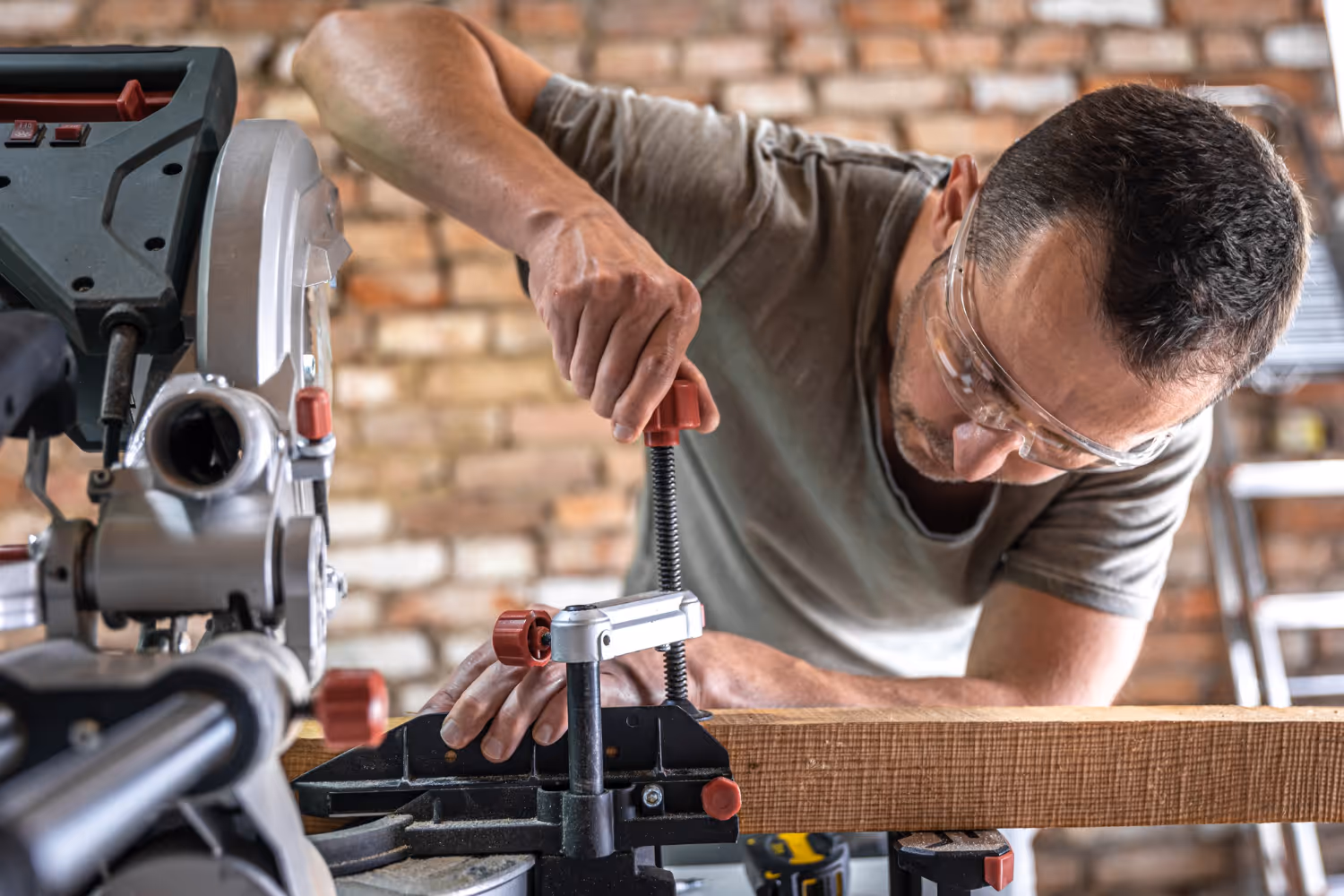 A man fixing wood to a workbench