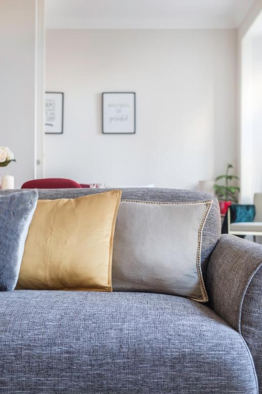 Gray fabric sofa with gold and gray pillows in a bright modern living room.