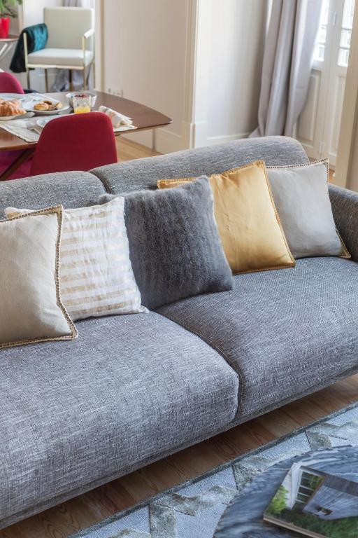 Gray sofa with five decorative pillows in neutral colors in a bright living room.