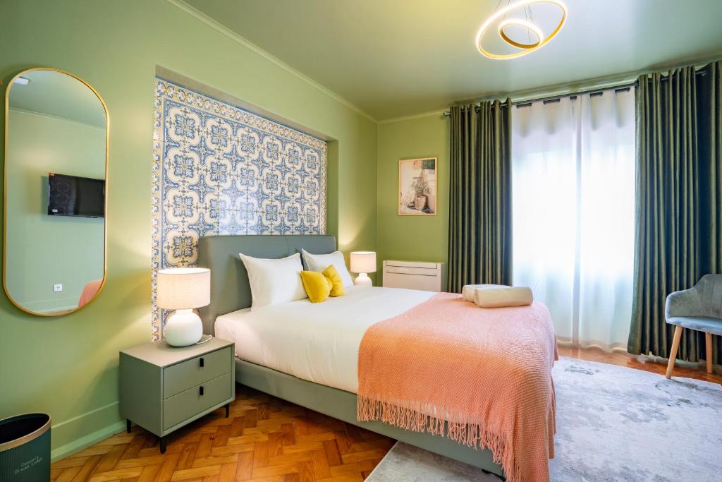 Modern bedroom with green walls, patterned tile headboard, white bed, yellow pillows, and peach throw.